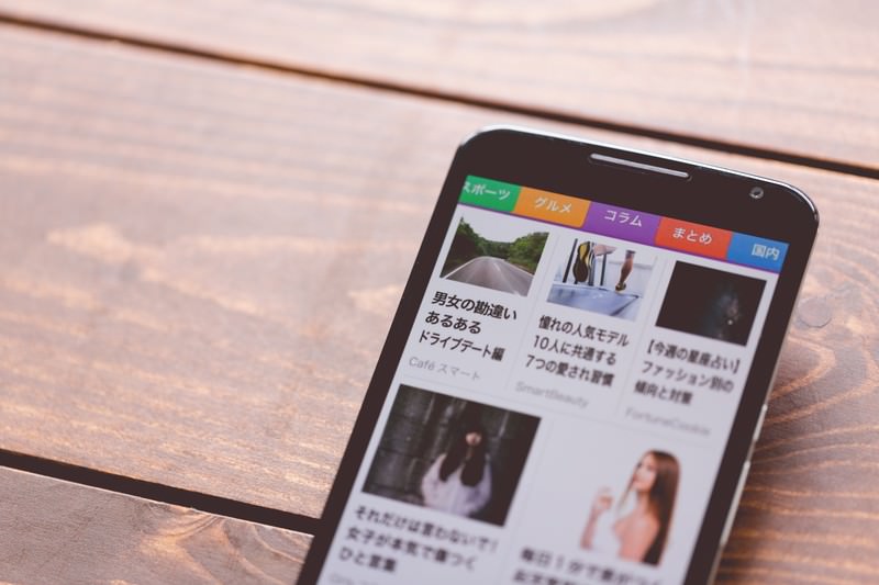 スマートフォンで各社のサービス内容を確認する様子