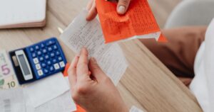 電卓と封筒で年収300万円のふるさと納税の上限額を計算するイメージ