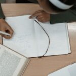 ノートパソコンと本、ノートで学ぶ社会人の学習デスク