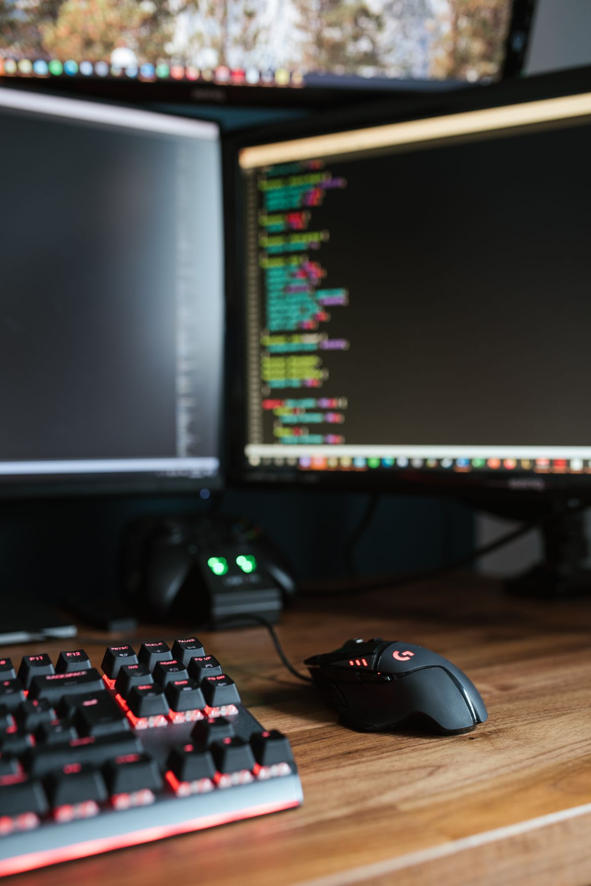 プログラムコードが表示された複数のモニターとキーボード