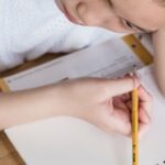 机に向かって学習する学生