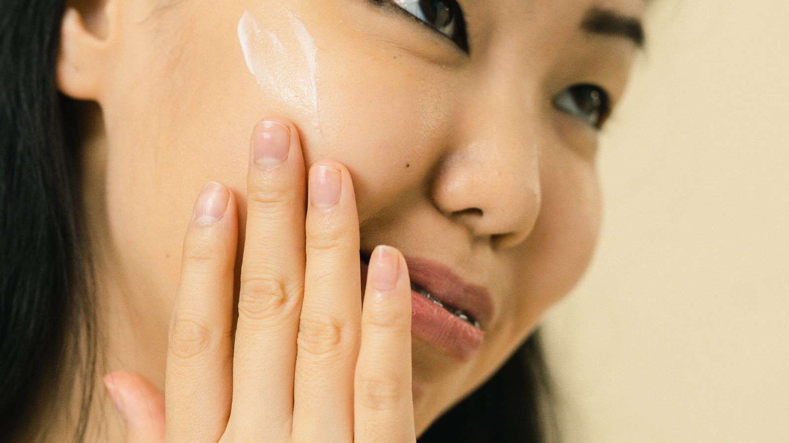 化粧水を頬になじませる女性