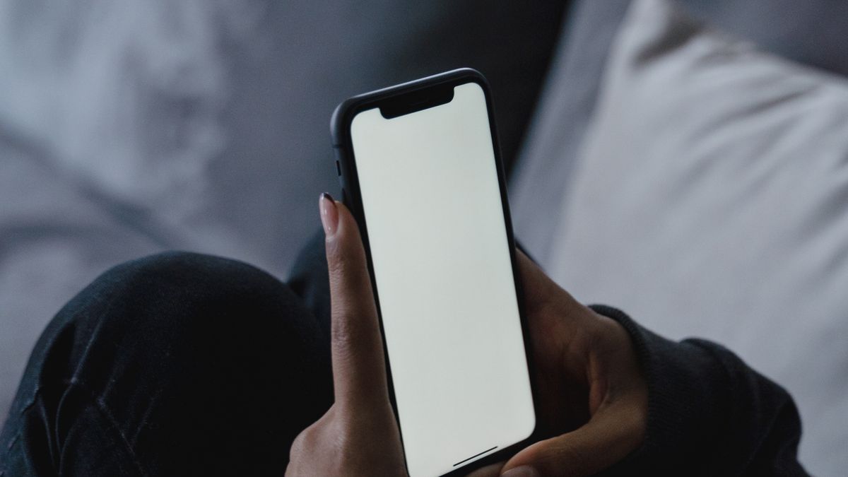 スマホを持つ人と通信のイメージ