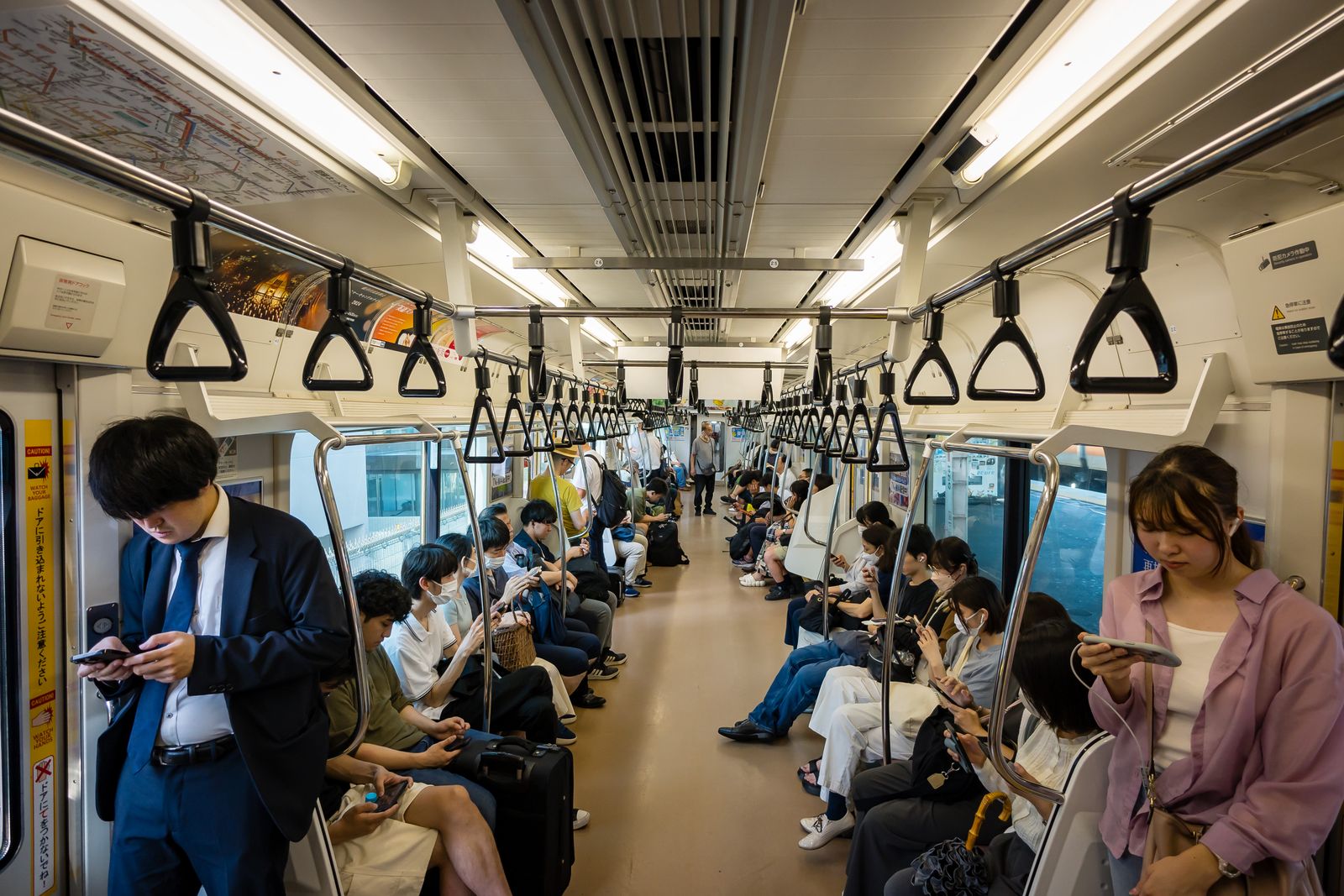 通勤電車の車内でスキマ時間を過ごす人たち