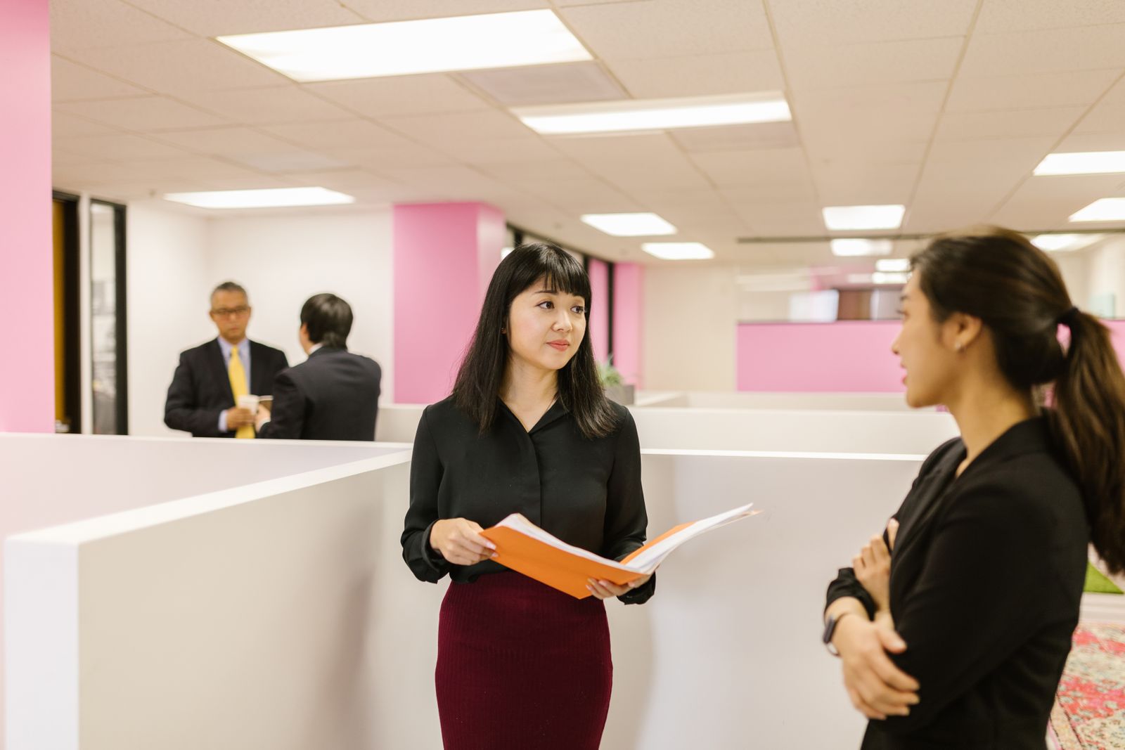 応募書類を手にオフィスを歩く女性