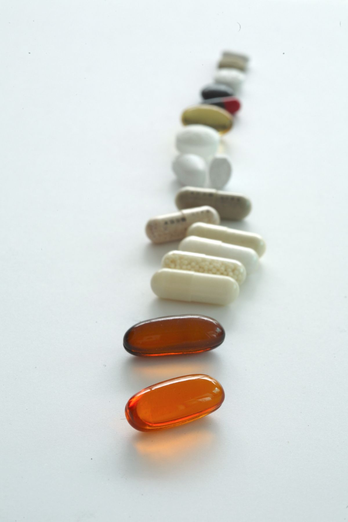 白い背景に並んださまざまな錠剤とカプセル。目的別に選ぶサプリメントのイメージ