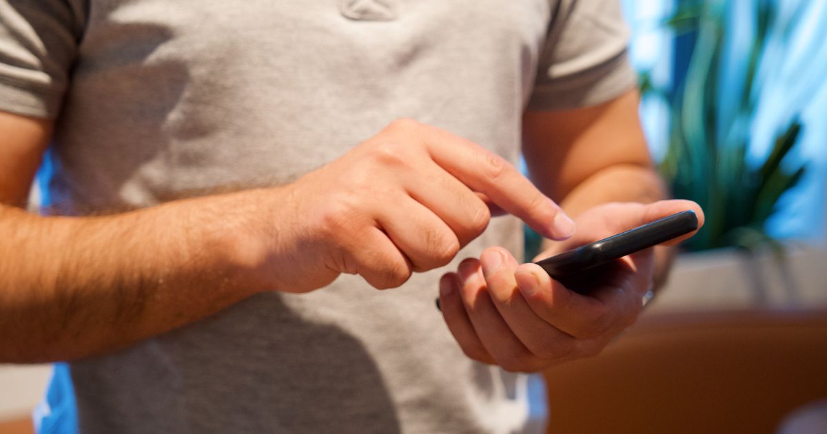 スマートフォンを手に持って操作している人