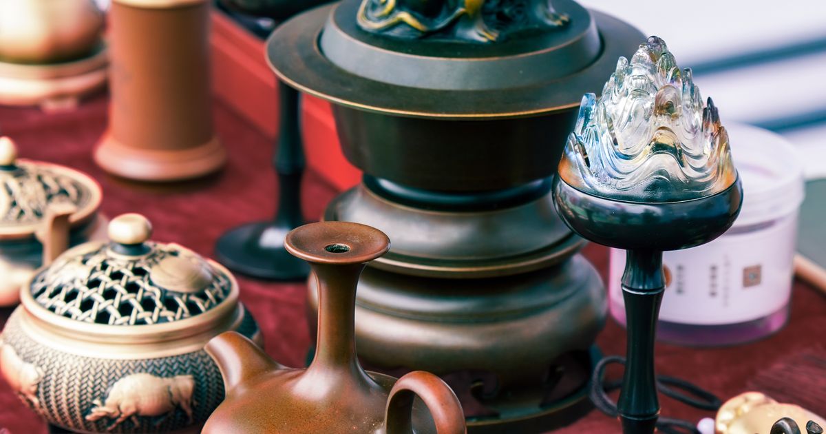伝統的な中国の陶磁器と金属製品をテーブルに並べたコレクション