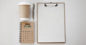 クリップボードと電卓が並んだ作業スペース