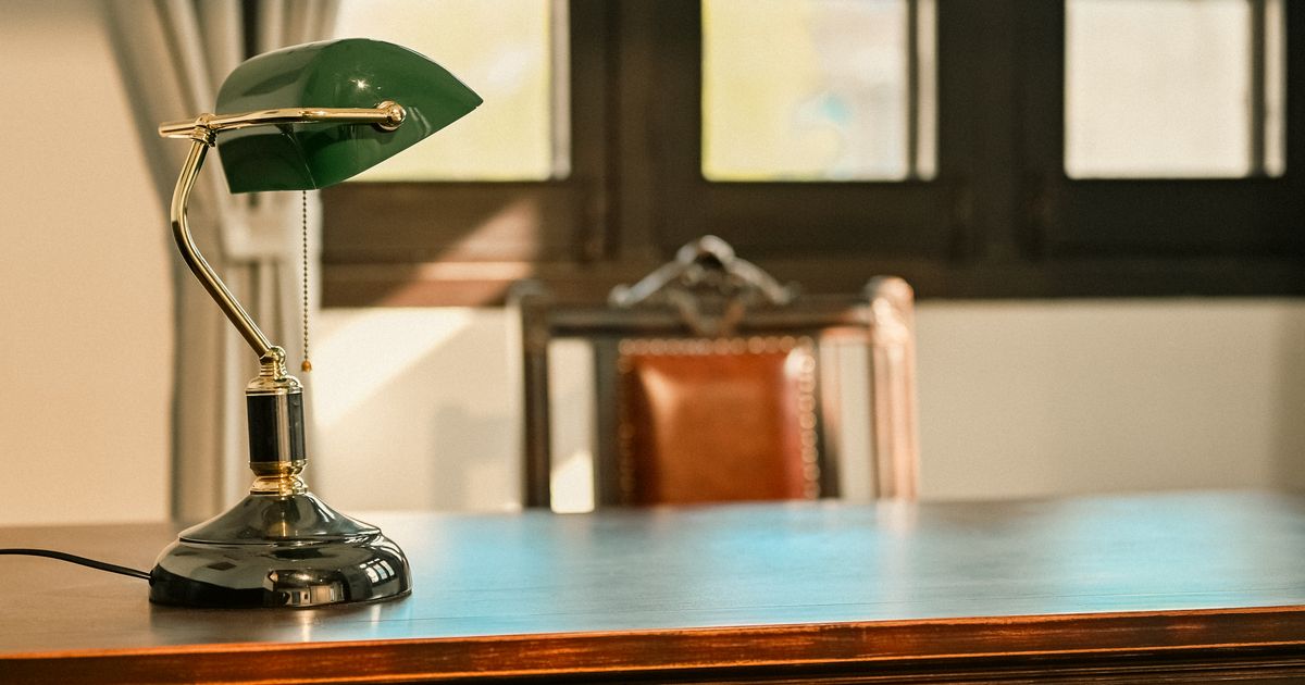 木製デスクとデスクランプのある書斎。オンライン授業を受ける学習環境のイメージ