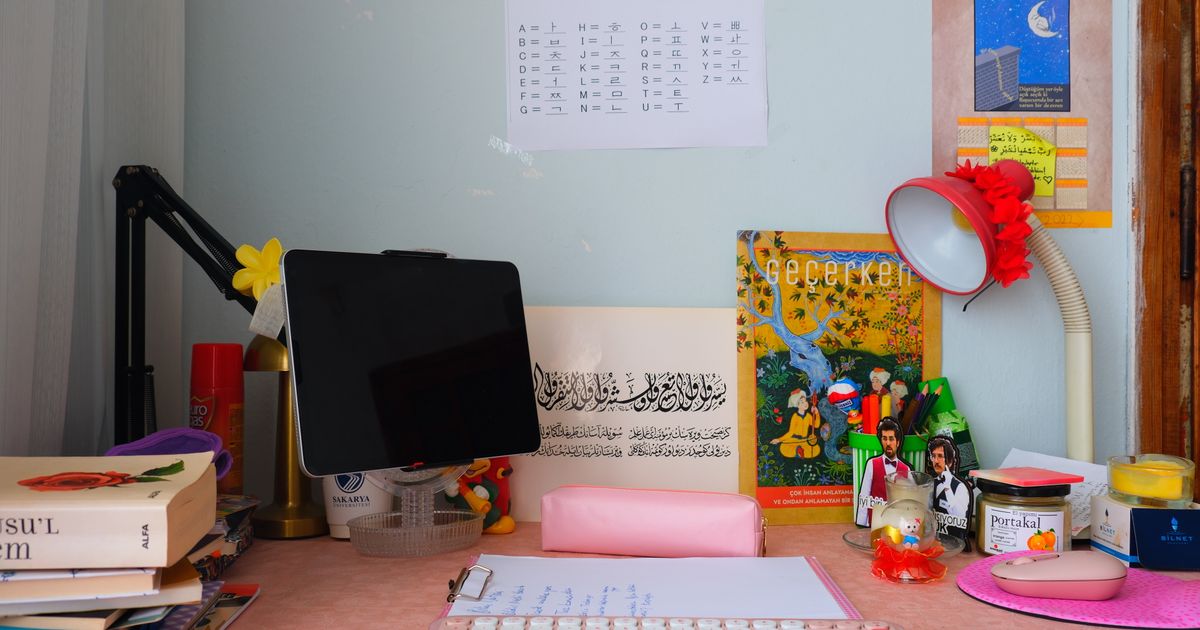 本とキーボード、タブレットが並ぶ整理された学習机