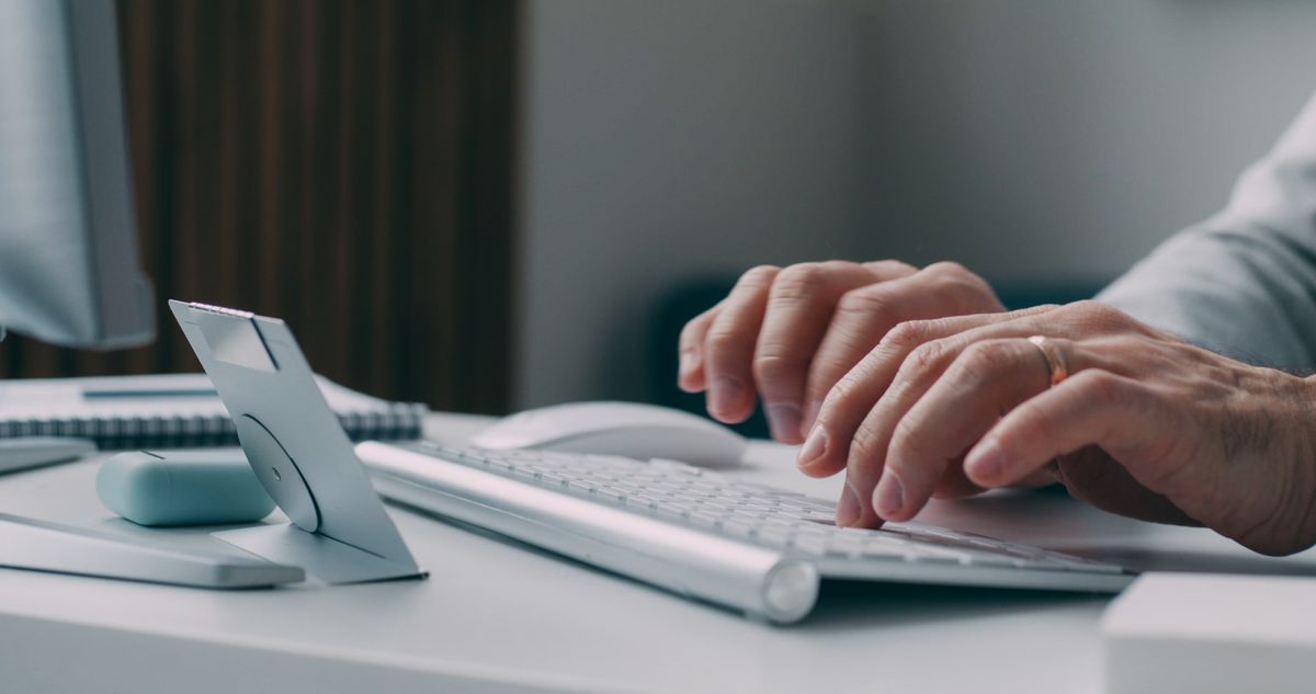 デスクのキーボードに手を置いて入力する様子