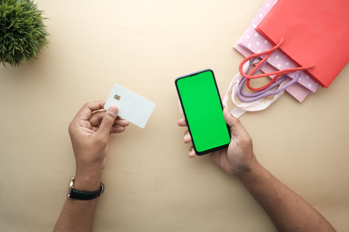 スマートフォンと買い物の小物を並べたフラットレイ。買い方を整理するイメージ
