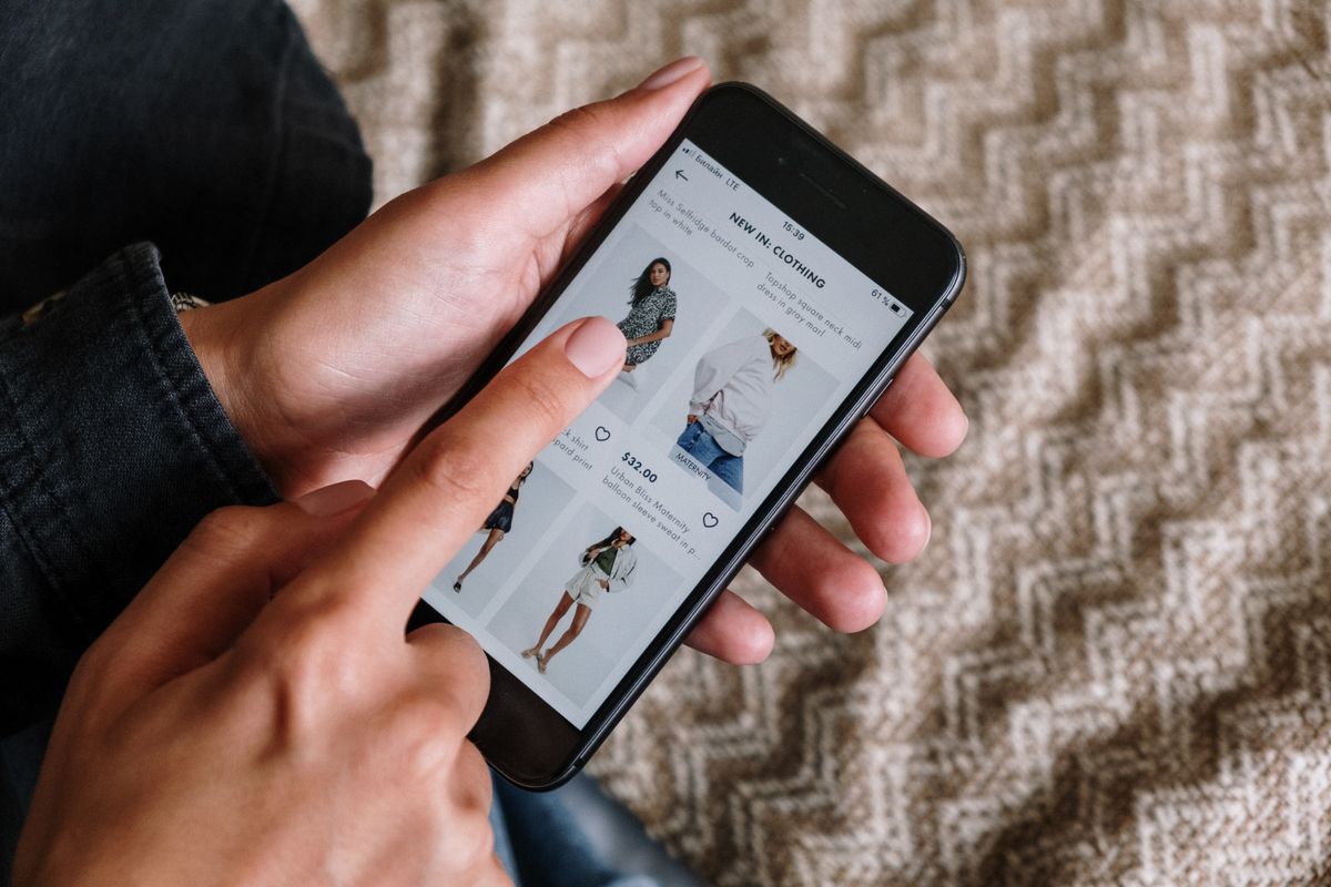 スマートフォンで商品を見比べる様子。買い方を見直すイメージ
