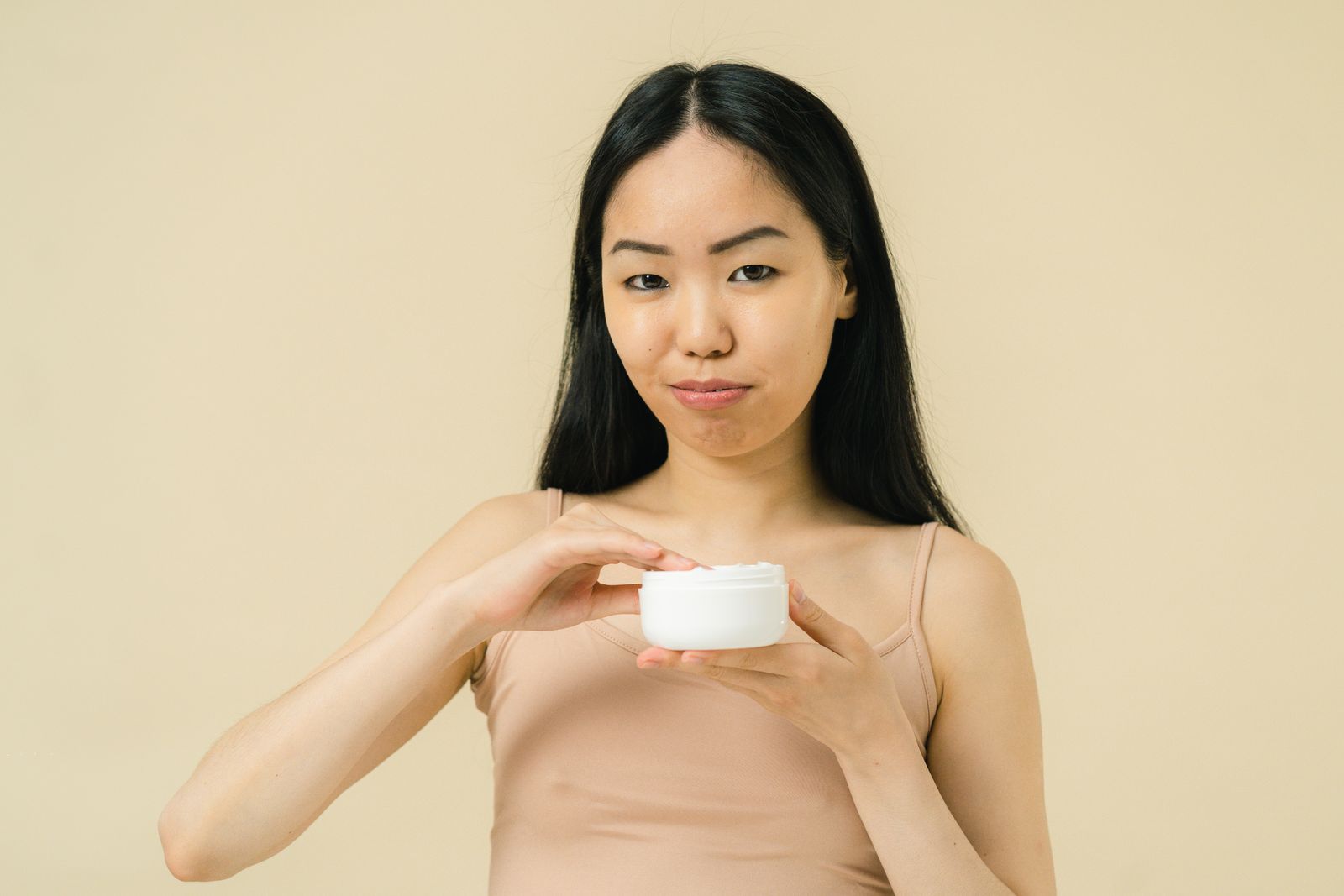 クリームを手に取ってなじませる様子